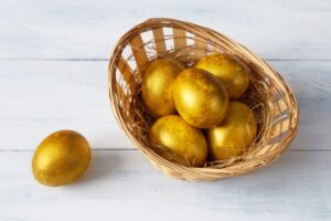 An image of a basket of gold-coloured eggs. Photo by Elena Leya on Unsplash.