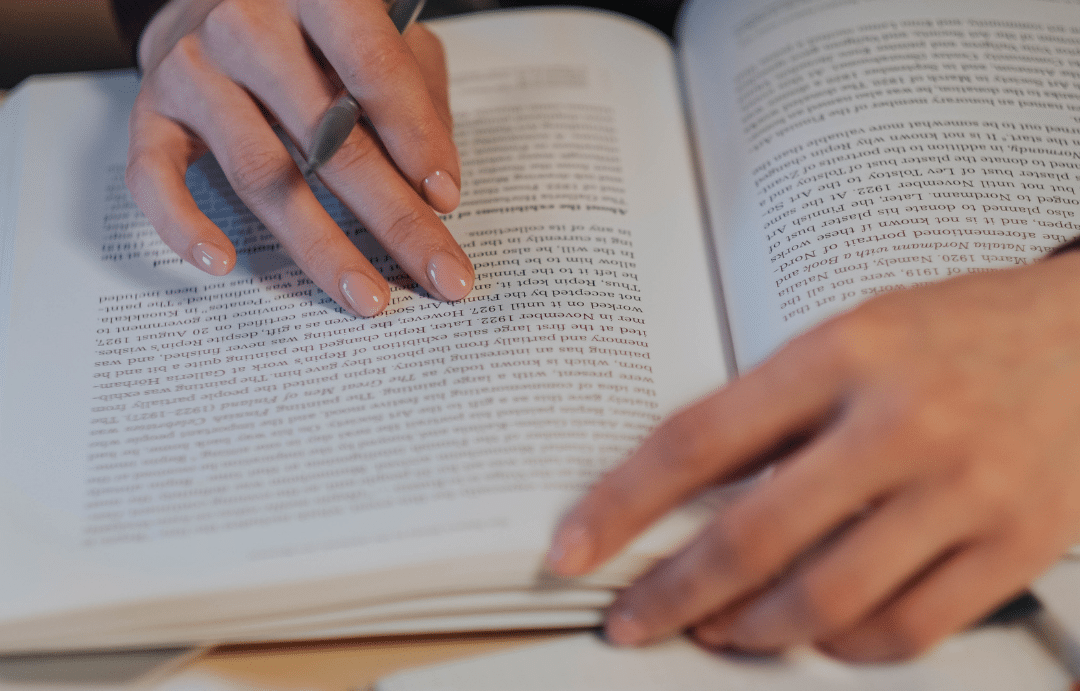 Person reading while taking notes. Image by Ron Lach