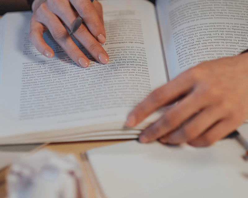 Person reading while taking notes. Image by Ron Lach