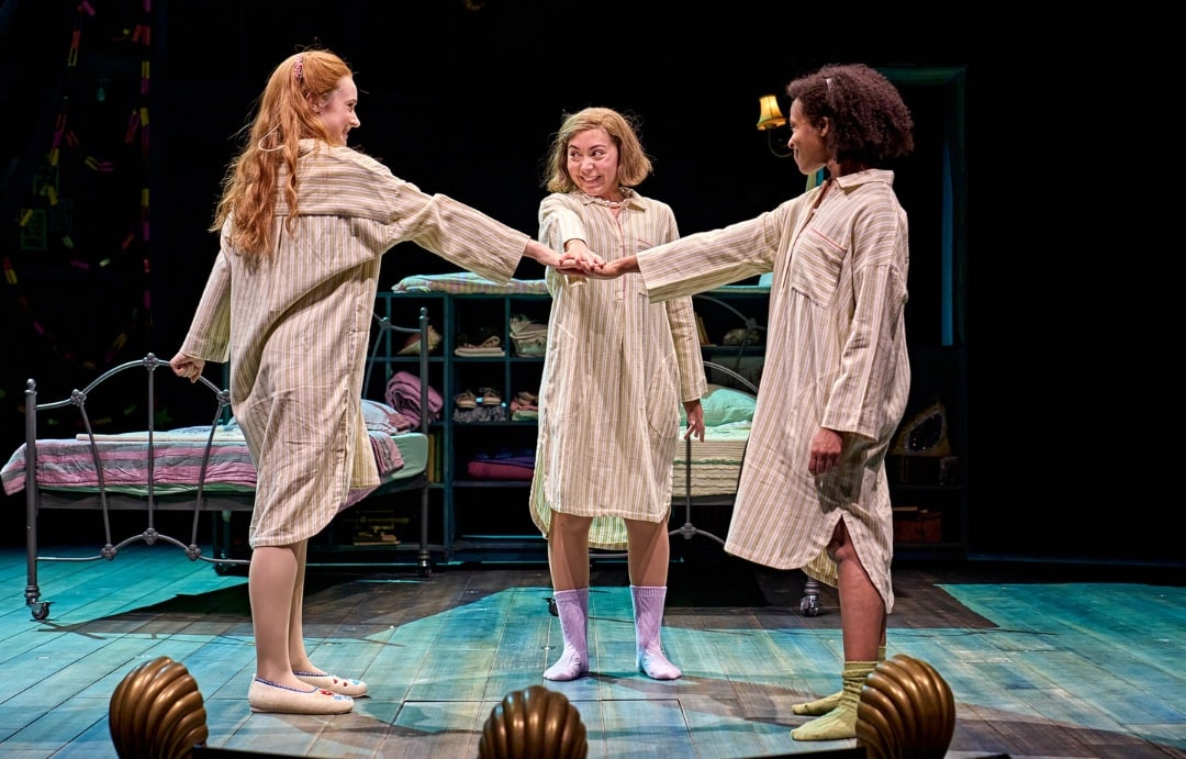Daisy Sequerra (Posy Fossil), Yanexi Enriquez (Petrova Fossil) and Grace Saif (Pauline Fossil) in Ballet Shoes at the National Theatre. © Manuel Harlan