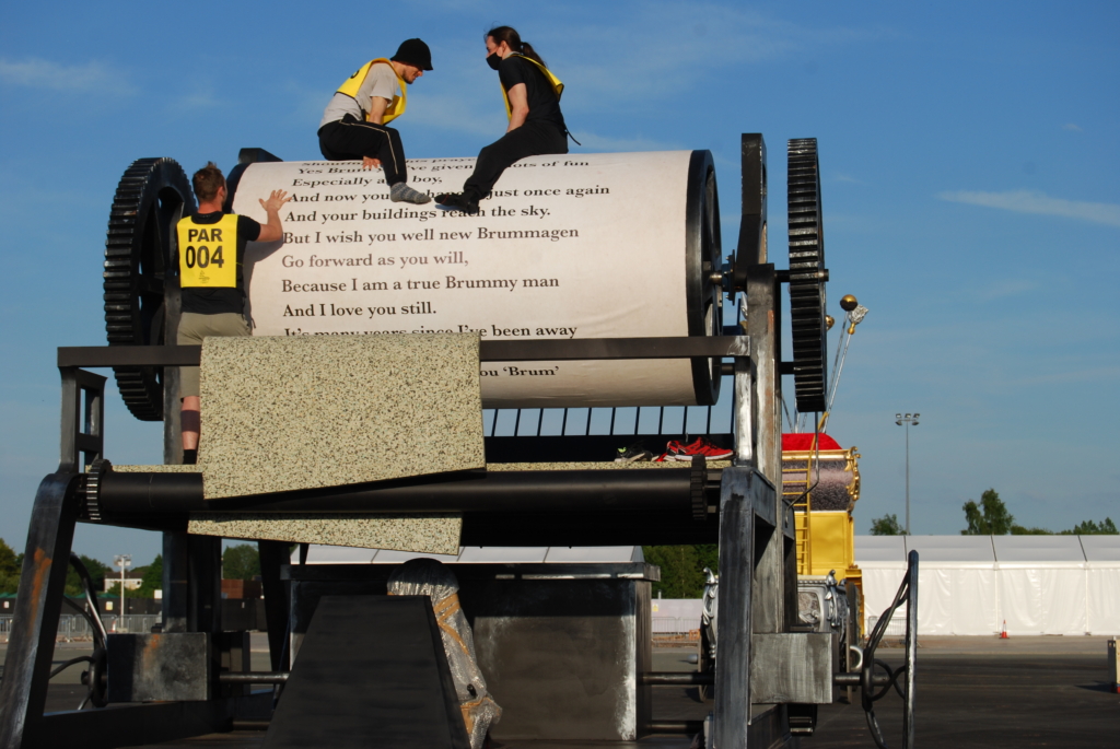 Parkour Riders volunteers construct a large-scale Printing Press, used in one of the sequences from the 2022 Commonwealth Games at the Alexander Stadium, Birmingham. © Maeve Clarke.